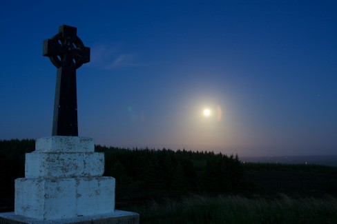 The moon glows brightly in the night sky near Bragan Penal Cross, Co. Monaghan