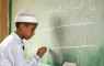 A young Iraqi boy practices his writing at a primary school in the Bayaa District of Baghdad, Iraq, Oct. 31, 2006. (U.S. Air Force photo/Master Sgt. Mike Buytas)