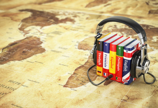 Learning languages online. Audiobooks concept. Books and headphones on the map world. 3d