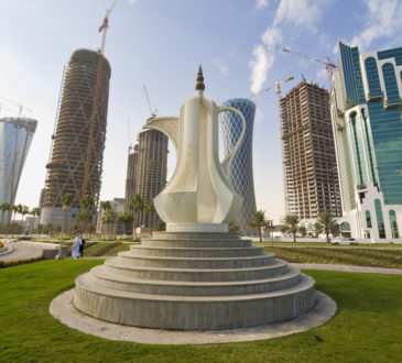 The Dallah coffee pot sculpture on the Corniche in Doha the capital of Qatar, behind it are the new high rise building being built to fill the skyline.