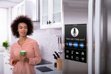 Woman Standing Near The Refrigerator With Voice Recognition