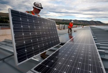 two workers installing solar panels
