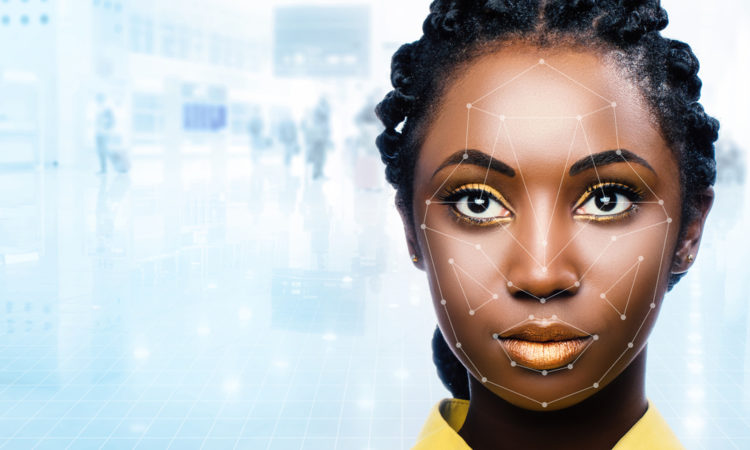 Close up portrait of attractive african woman with facial recognition technology. Grid with reference areas marked on face. Young girl against out of focus airport background.