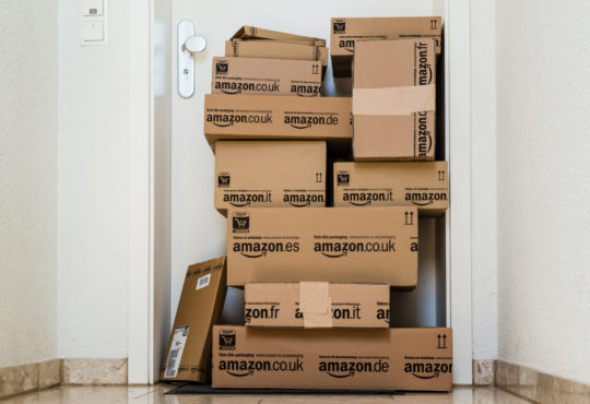 Amazon packages in front of an apartment.