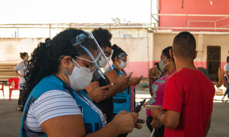 Reporters take down a resident's data in the Jacarezinho favela, Rio de Janeiro.